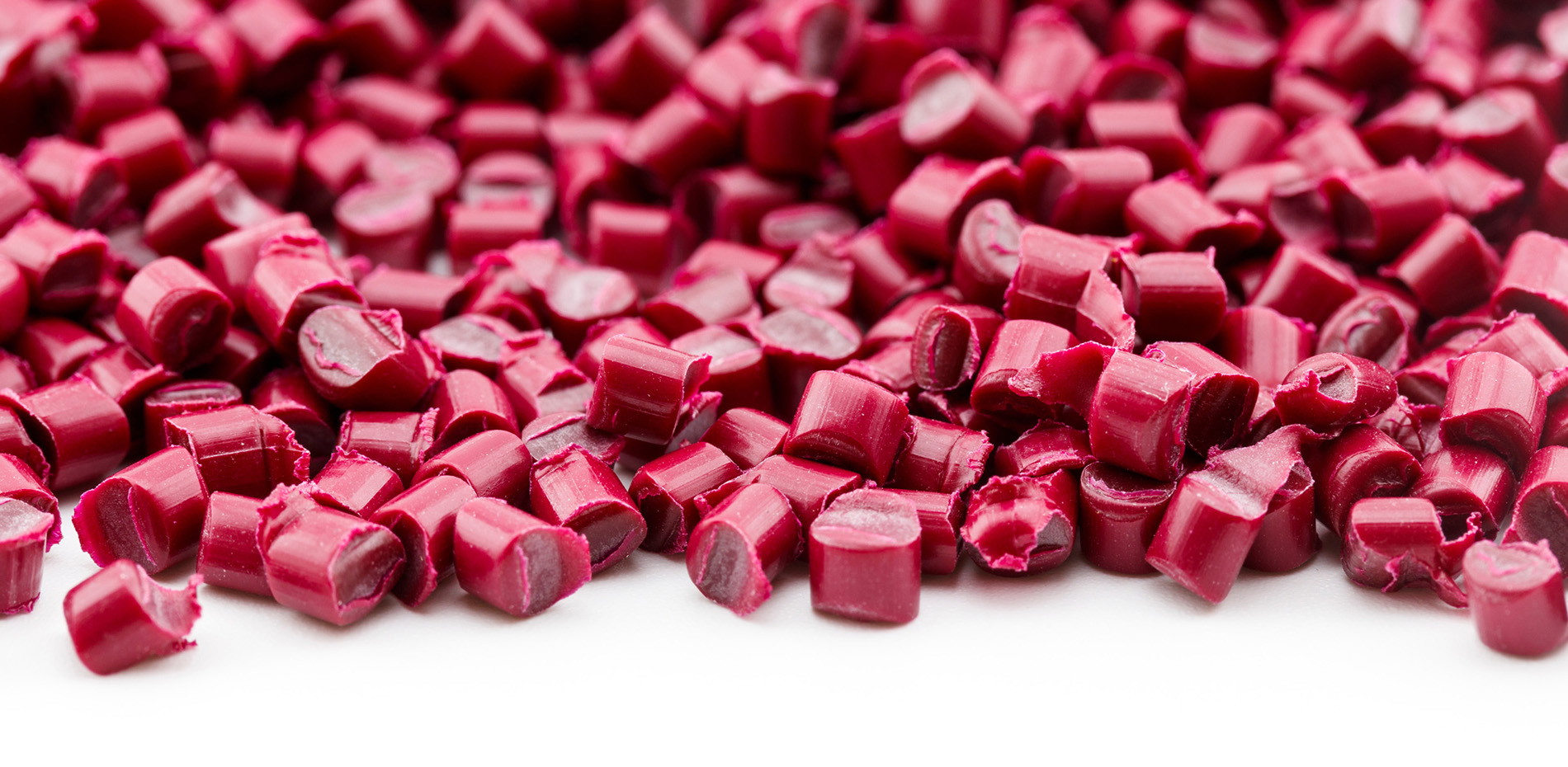 Rote Kunststoff-Masterbatch-Granulate auf hellem Hintergrund – Beispiel für präzise Einfärbungslösungen von HABICH FARBEN für die kunststoffverarbeitende Industrie.